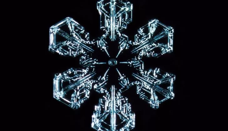 Closeup of one snowflake against a dark background
