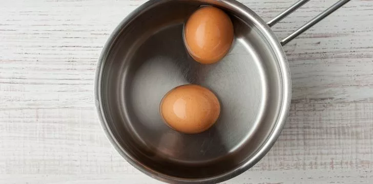 Two eggs in a pan of water.