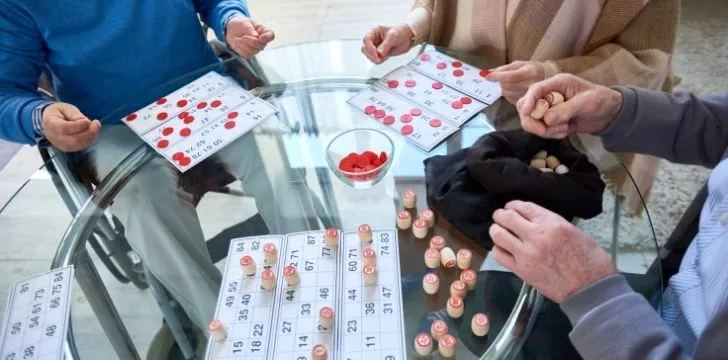 A group of men and women playing Bingo together.