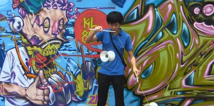 Young man in the modern day playing diabolo.