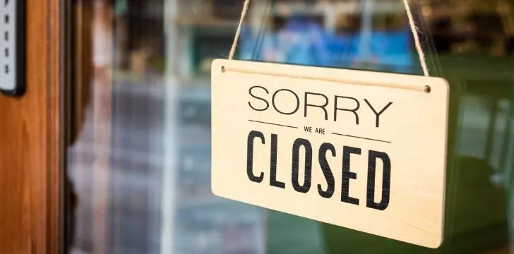 A sign on a store door that says 'Sorry we are closed'.