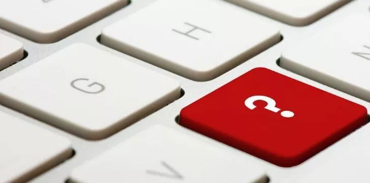 A picture of a white keyboard with white keys but the question mark is red.