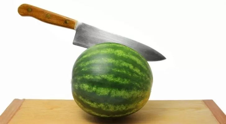 A watermelon thats been attacked by a knife