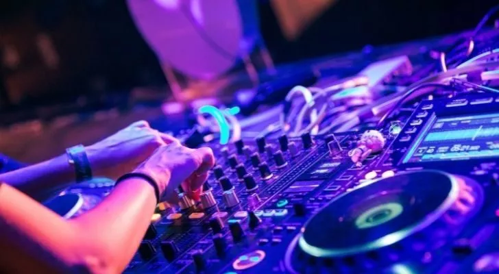 Someone playing DJ decks at a nightclub