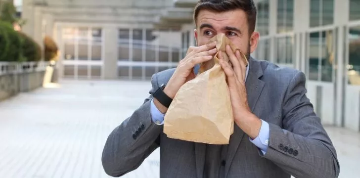 A man breathing through a paper bag