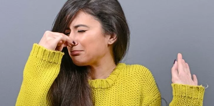 A woman holding her nose 