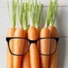 Carrots on a woodern background wearing glasses.