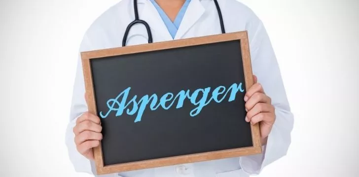 A doctor holding a chalkboard that reads Aspergers on it