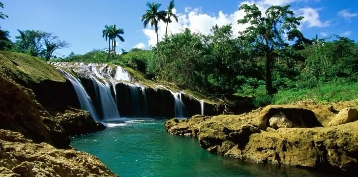 A picture showing a river, lush blue lagoon and green land.