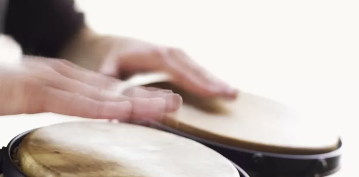 Bongo drums being played with both hands.
