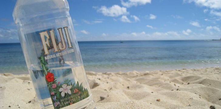 Una botella de agua de Fiji en una playa