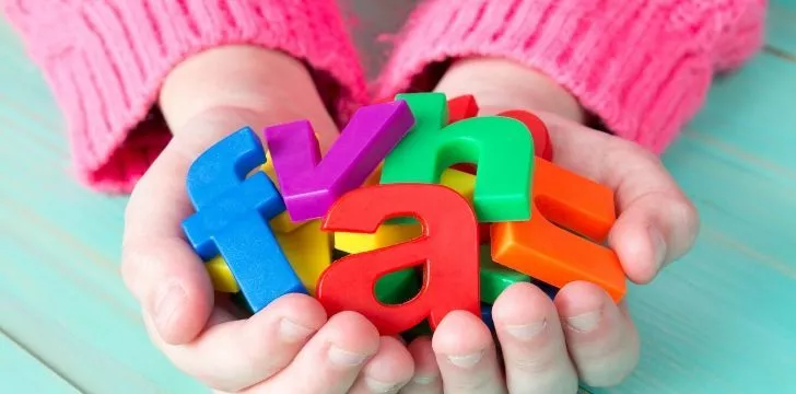 A girl holding magnetic letters