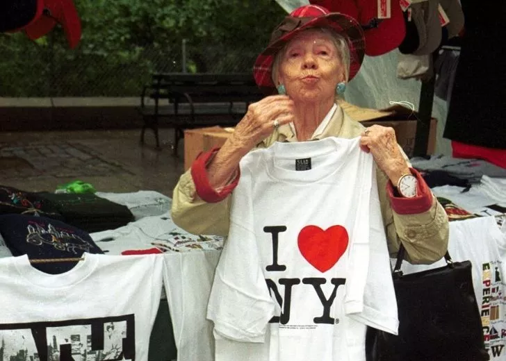 An older lady holding up a t-shirt that reads "I Heart NY"
