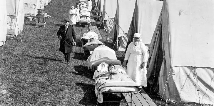Nurses assisting sick people outside tents in the outdoors