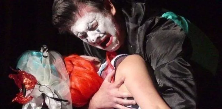 A clown holding a woman in his arms in the opera called Pagliacci