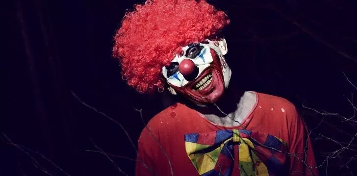 A scary clown in a blood red wig