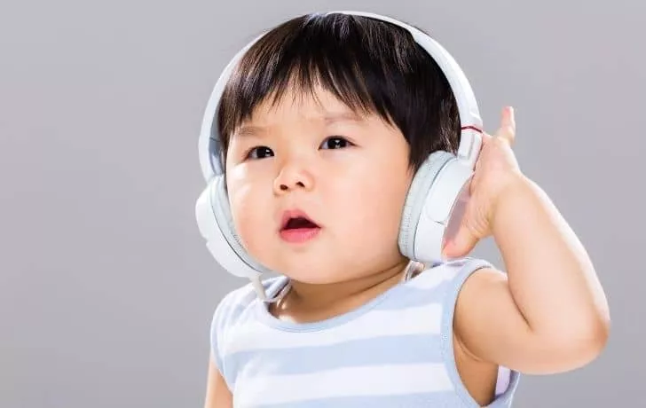 A baby listening to music on headphones