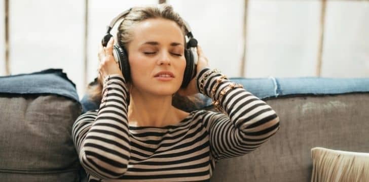 A woman happily listening to music on headphones