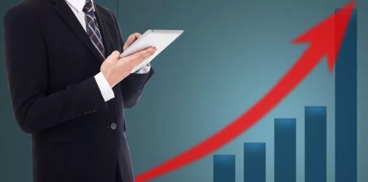 A man in a suit and a graph showing an increase