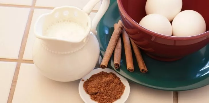 Eggnog ingredients egg, milk, and cinnamon