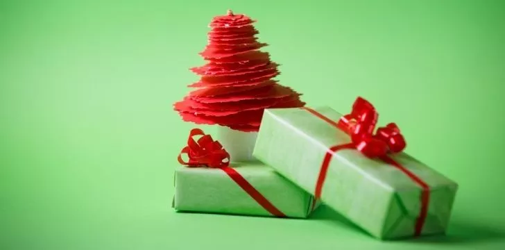 Two gifts wrapped in green paper with red ribbons