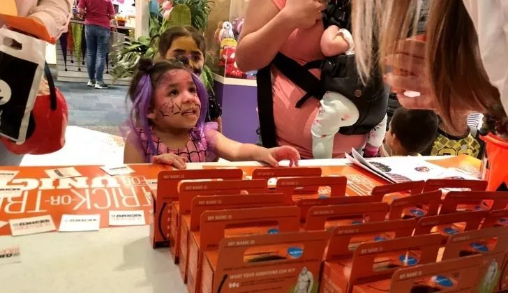A girl being gifted a Halloween box by Unicef
