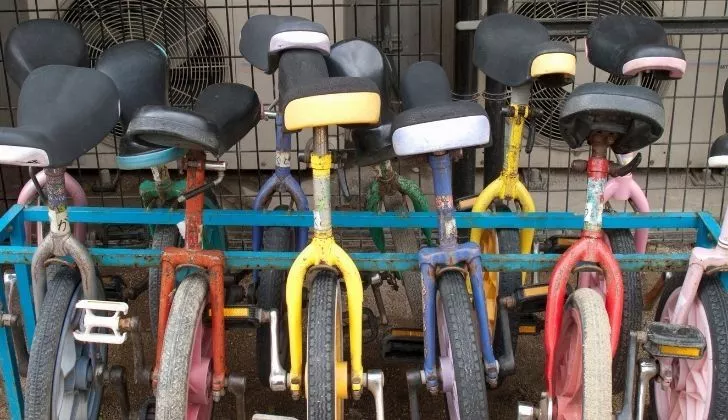 Rows of unicycles against a metal rack
