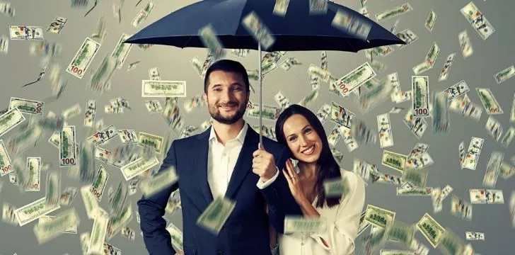 Two people under an umbrella taking cover from the raining money