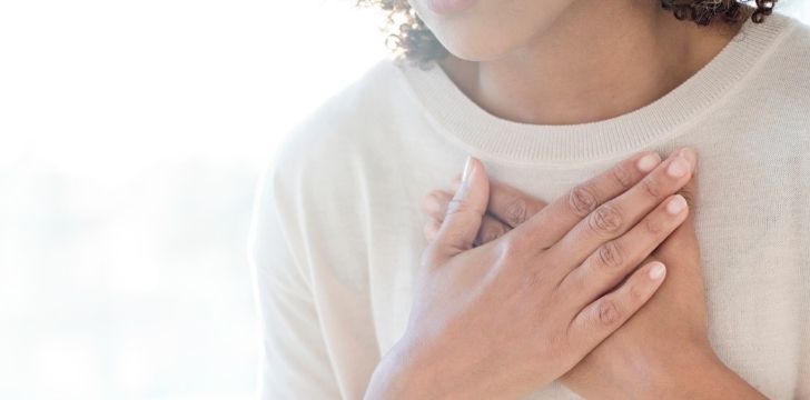 A woman holding her hands to her chest