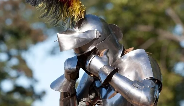 Someone wearing a full metal Medieval knight outfit
