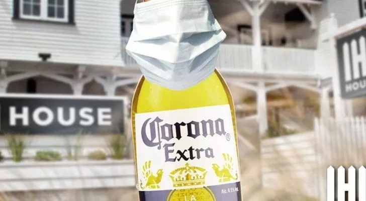 A Corona beer bottle being socially responsible wearing a face mask