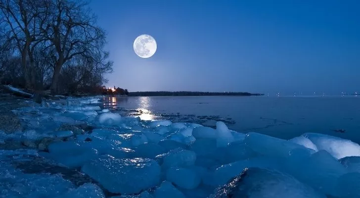 A snow moon with a snowy icy landscape on Earth