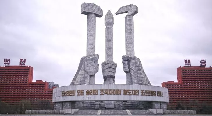 A famous landmark in North Korea showing three hands holding tools
