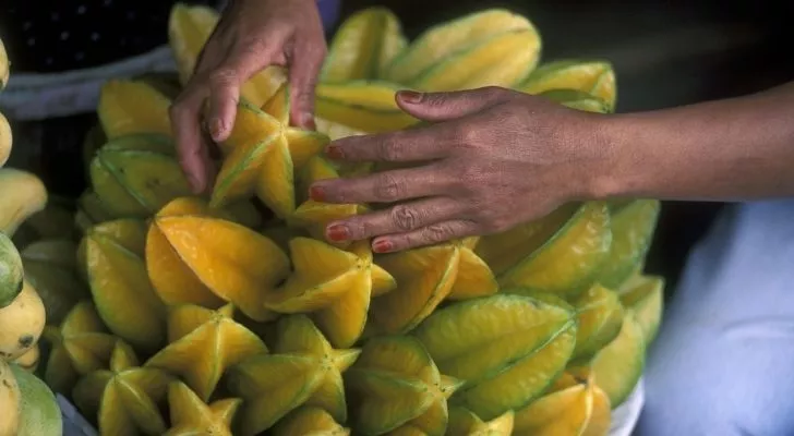 Someone handling many starfruit