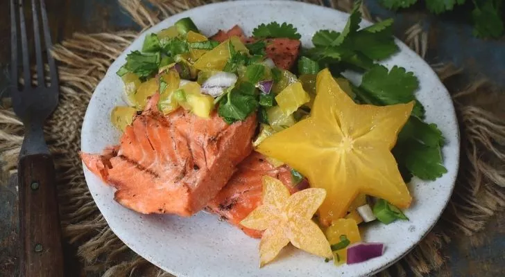 Cooked salmon with salad and star fruit