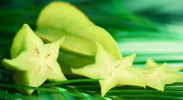 A green star fruit sliced down the middle