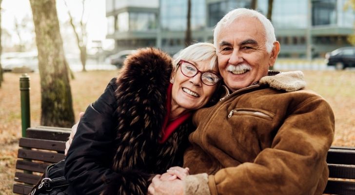 An older couple hugging and looking happy and relaxed
