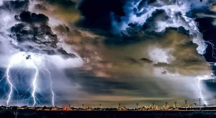 Thick heavy clouds and lightening across a city