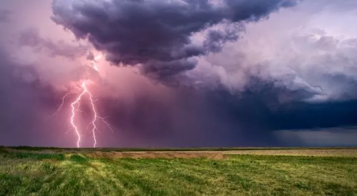 A thunderstorm across a grass field