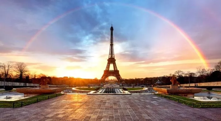 Eiffel Tower with a rainbow arched across it in the sky