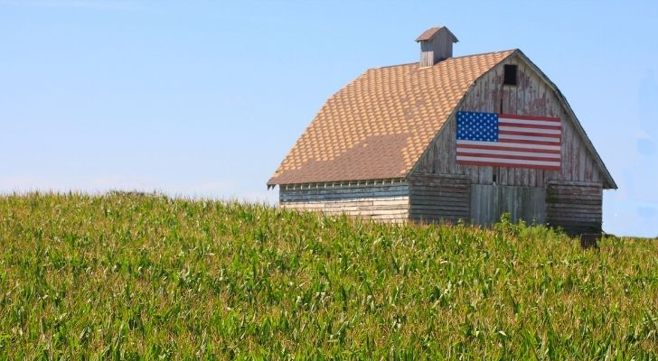 A farm hut with a large US flag on it
