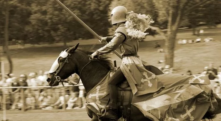 A man riding a horse while jousting