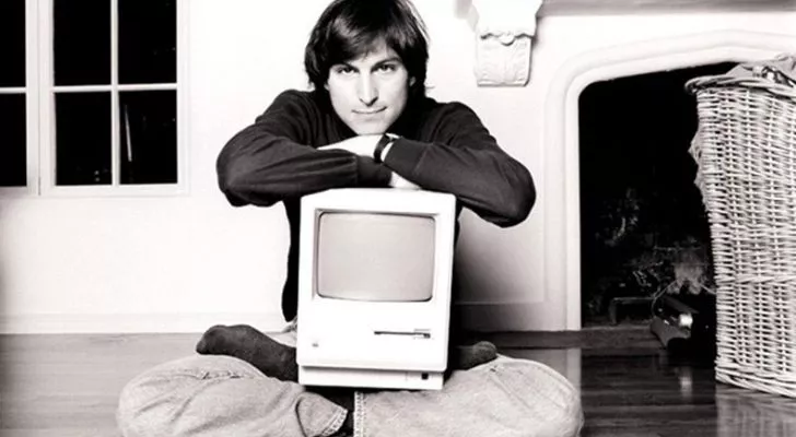 Steve Jobs me një kompjuter Apple në prehrin e tij