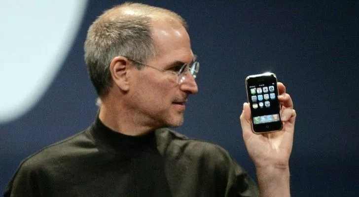 Steve Jobs ilk iPhone'u elinde tutuyor