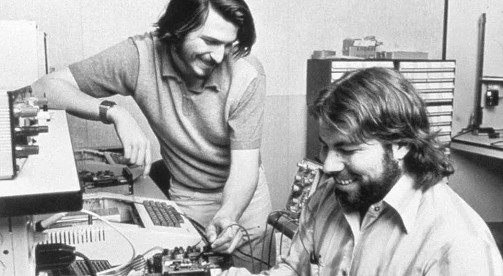 Steve Jobs and Steve Wozniak working on a computer