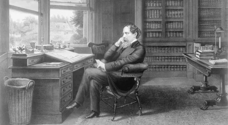 Charles Dickens sitting at an office table