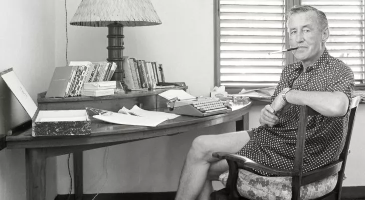 Ian Fleming sitting at his writing desk