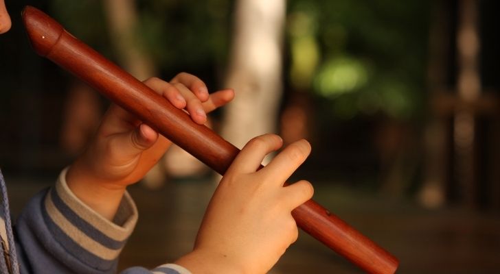 A kid playing the recorder wind instrument
