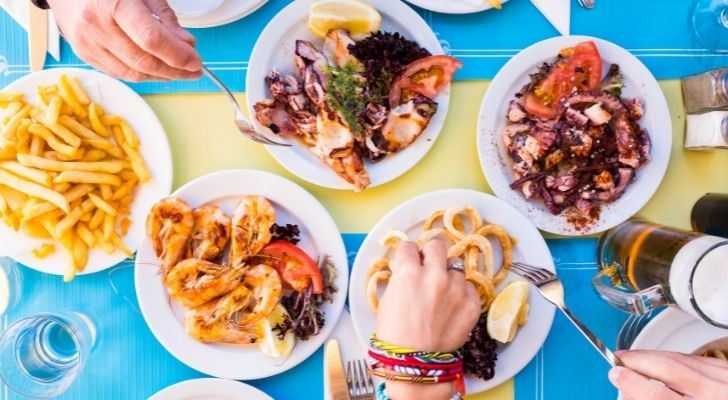 La gente come mariscos en una mesa de comedor.
