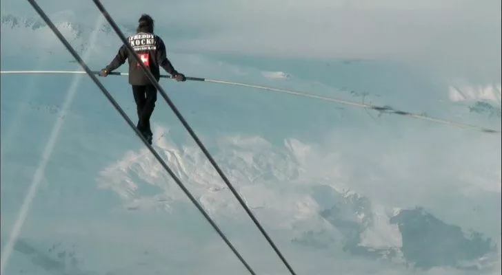 Freddy Rock walking a zip line that's incredibly high